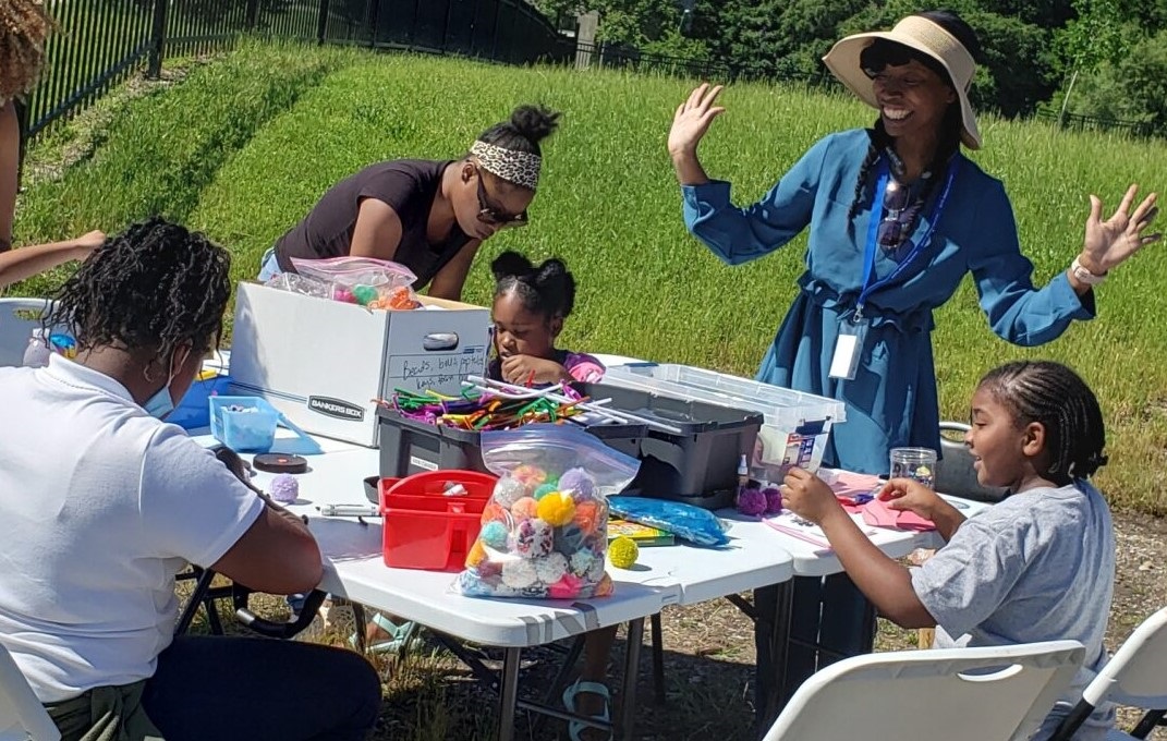 Library staffer doing crafts with kids and parents