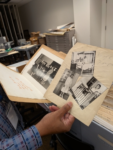 A man's hand holds black and white photos.
