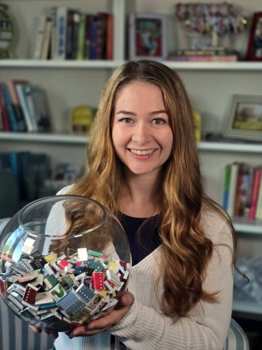 Rachel Pierce holds a glass bowl with tiny books for her Book Bowl Challenge.