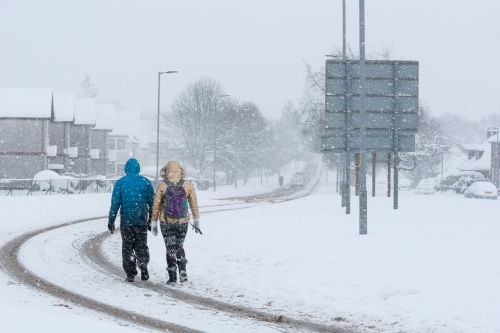 Two people walking on a snowy day