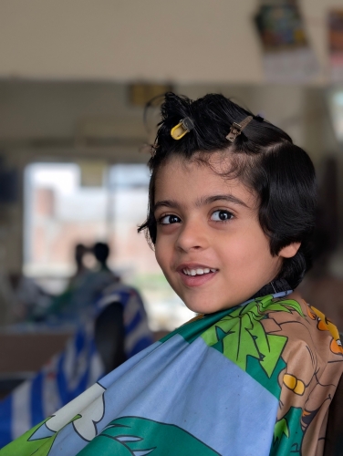 A child in a barber's chair.