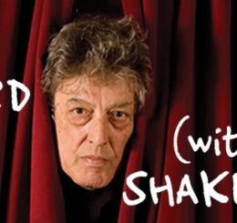 man's head peeks through red velvet curtain