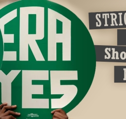 two people hold up circular signs