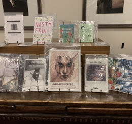 Photo shows several zines displayed on a table.