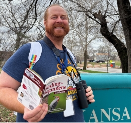 Ruiz Branch Manager Jimmy Thomas models a birdwatching kit near the branch sign.