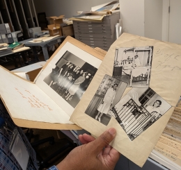 A man's hand holds black and white photos.