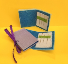 two sewing wallets with hand needles