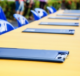 long table with clipboards and blue chairs