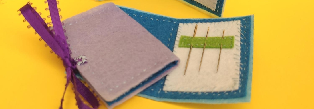 two sewing wallets with hand needles
