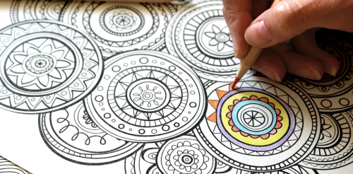 person using colored pencil on page