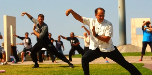adults doing tai chi outdoors